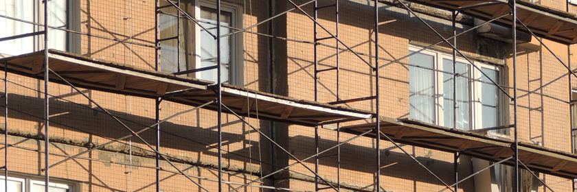 Échafaudage dressé devant la façade en brique d’un immeuble en rénovation